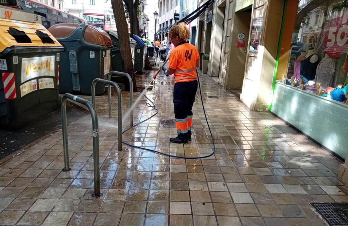 Empleado de limpieza baldeando las calles